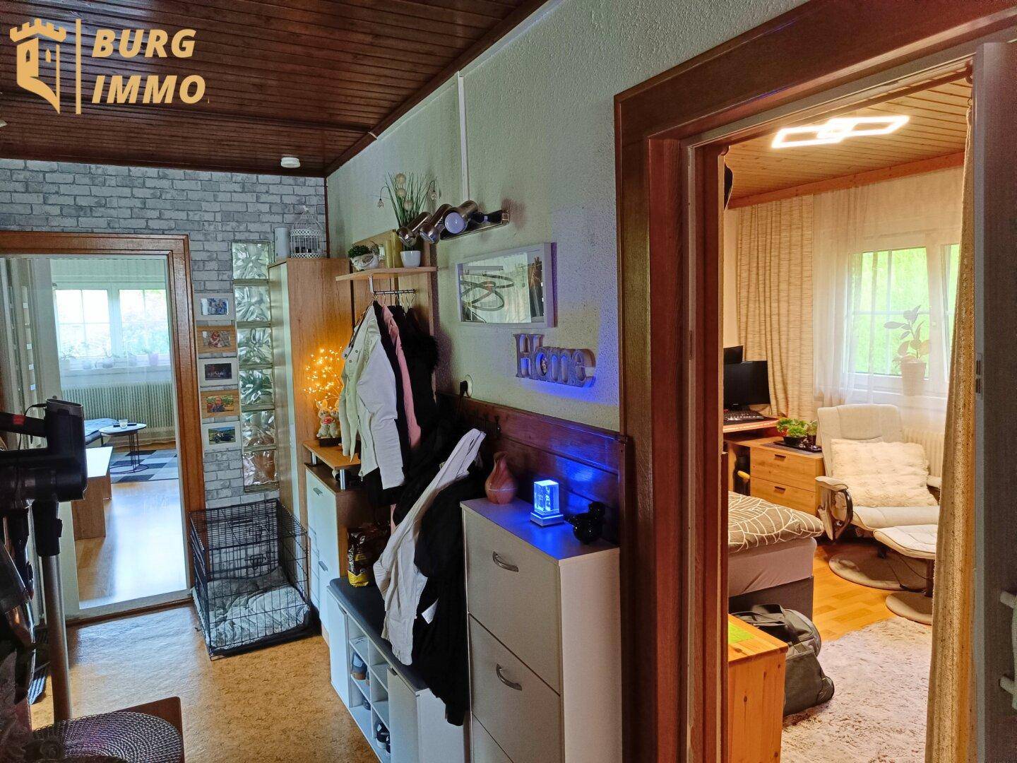 Eingangsbereich mit Holzdecke, Garderobe und Blick in angrenzende Wohnräume.