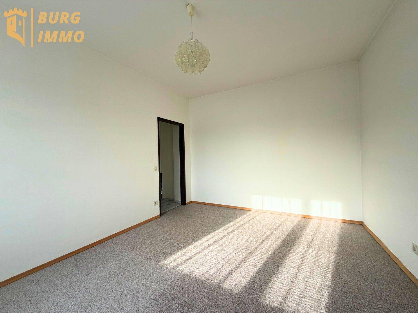 Geräumiges Schlafzimmer mit Teppichboden und viel natürlichem Licht.