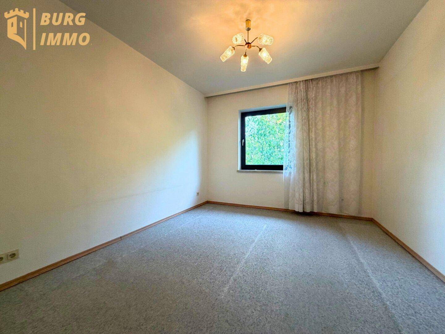 Helles Schlafzimmer mit Teppichboden, Vorhängen und Fenster.