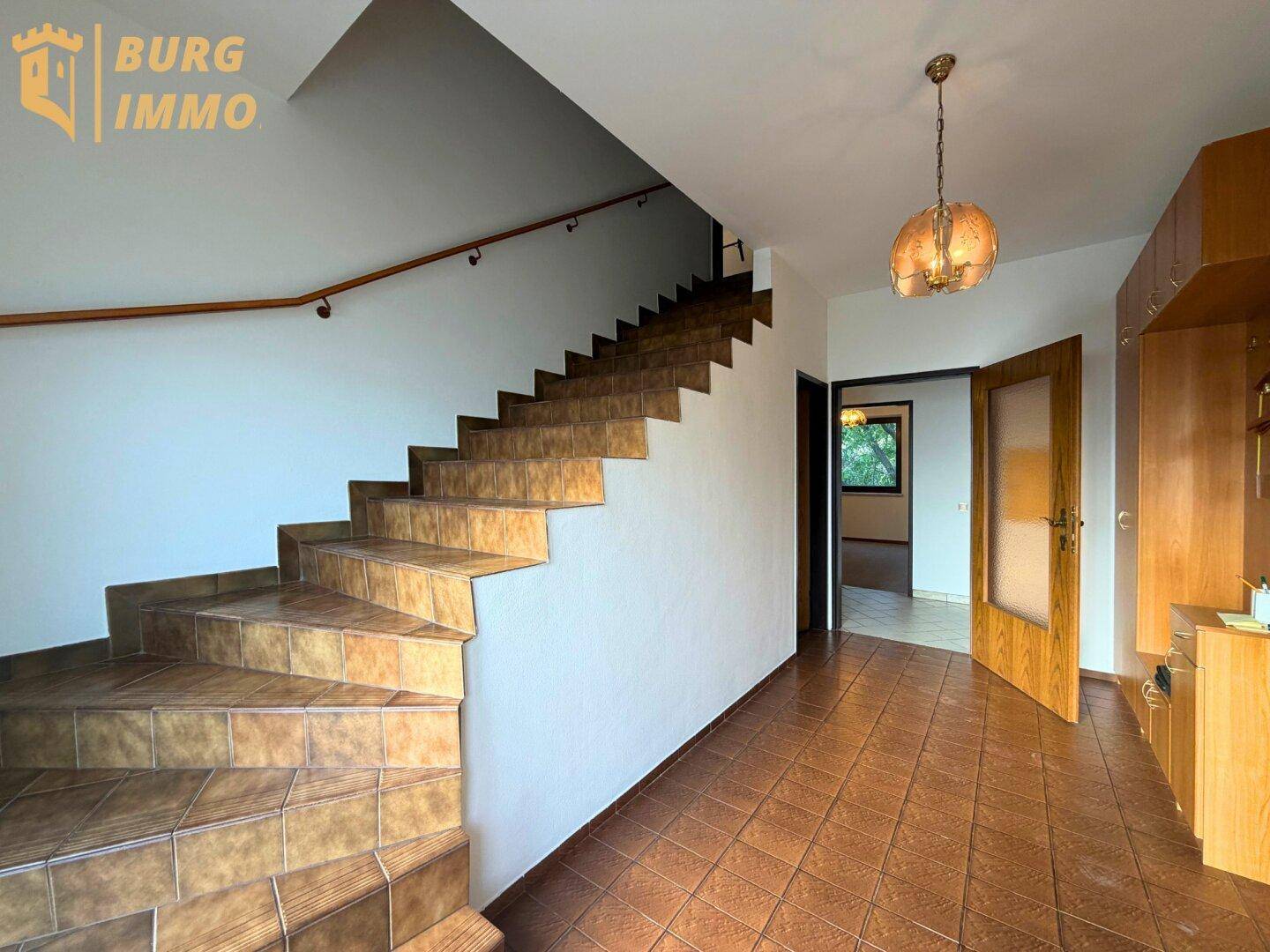 Geräumiger Flur mit gefliestem Boden und Treppe zum Obergeschoss.