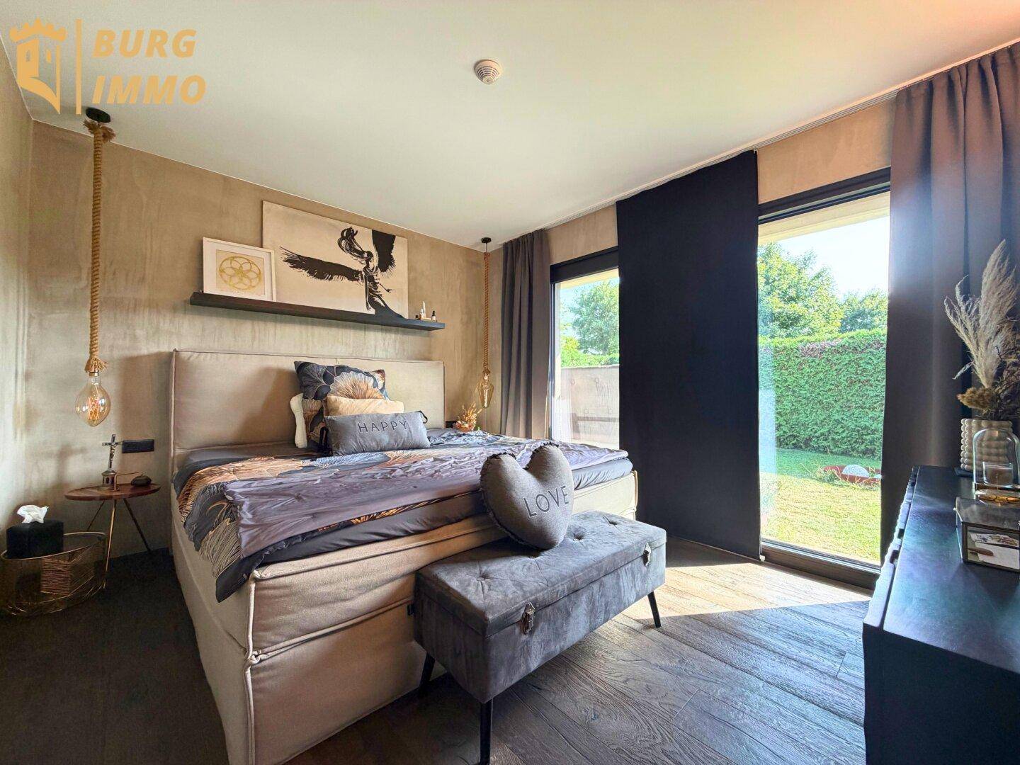 Gemütliches Schlafzimmer mit großem Bett, Holzboden und direktem Blick in den Garten.