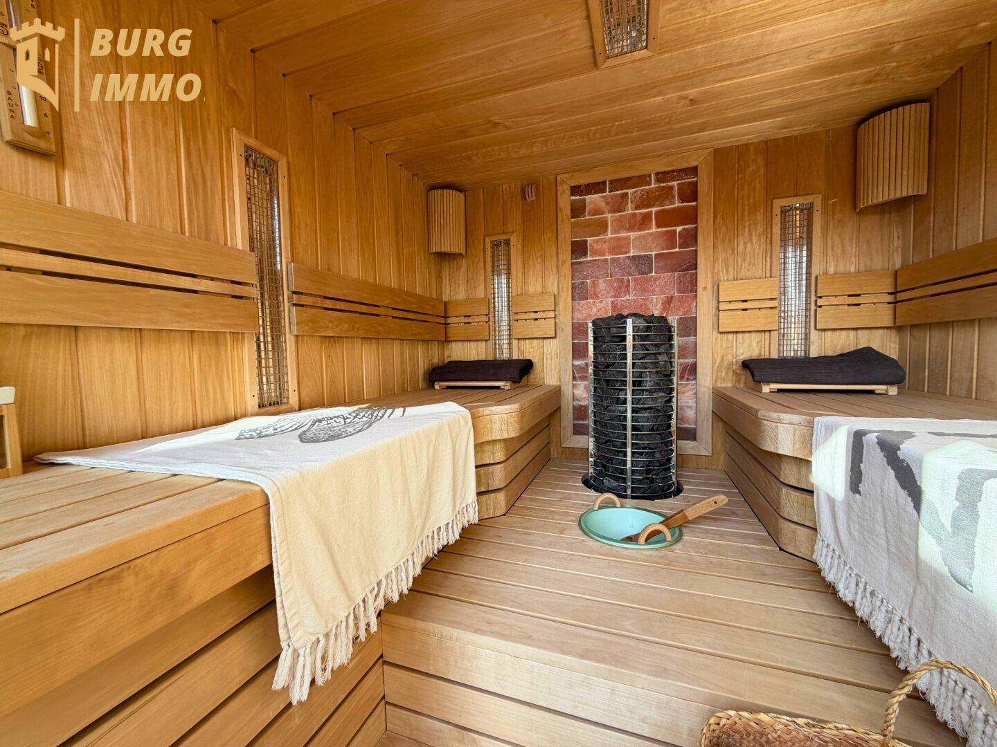 Traditionelle Holzsauna mit mehreren Bänken und einem Saunaofen für entspannende Momente.
