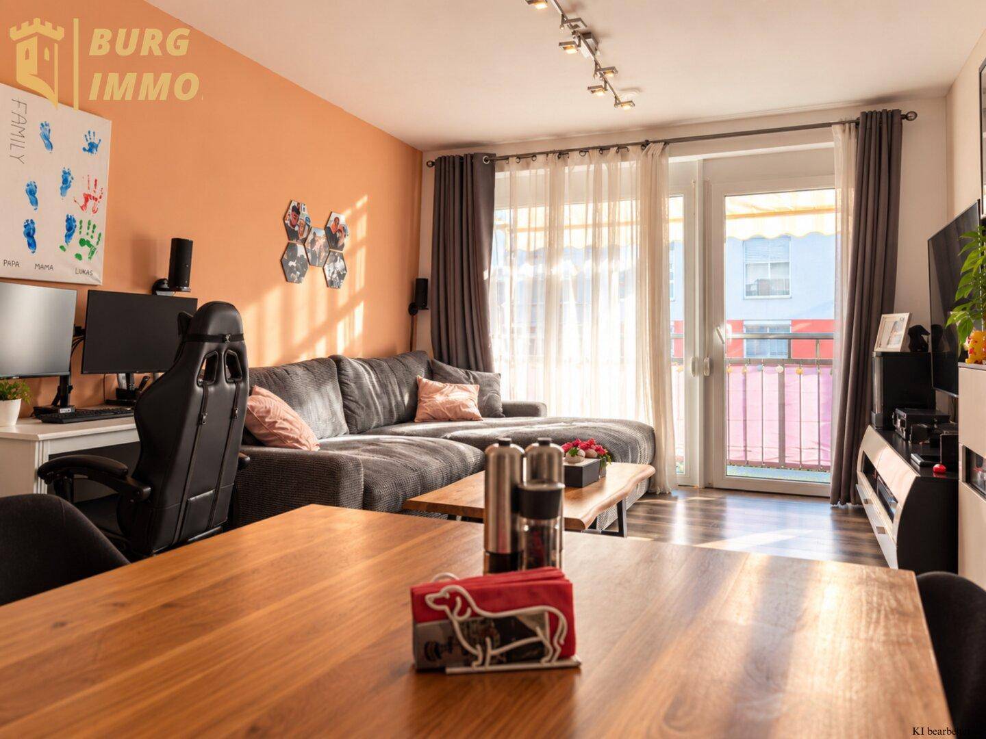 Heller Wohn- und Essbereich mit großem Sofa, Holztisch und Zugang zum Balkon.