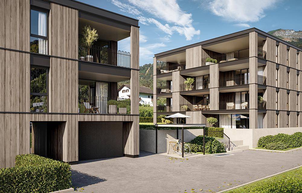 Detailansicht der modernen Fassade mit Holzverkleidung und Balkonen, umgeben von gepflegten Grünflächen.