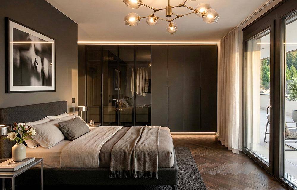 Modernes Schlafzimmer mit dunklen Einbauschränken, Parkettboden und Zugang zum Balkon.