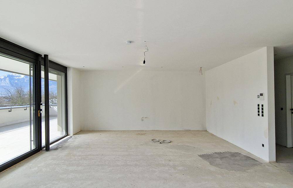 Heller Rohbau mit großen Fensterfronten und Blick auf die umliegende Landschaft.