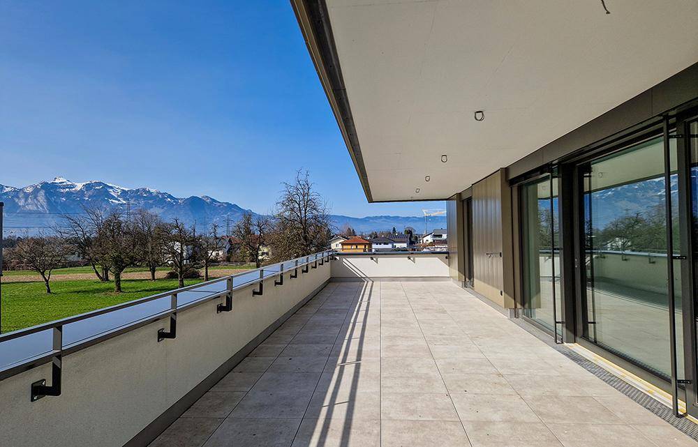 Weitläufige Terrasse mit Fliesenboden und beeindruckendem Bergblick in der Ferne.