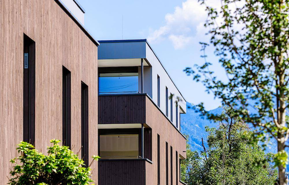 Moderne Architektur mit Holzfassade und Blick auf die umliegende Berglandschaft.