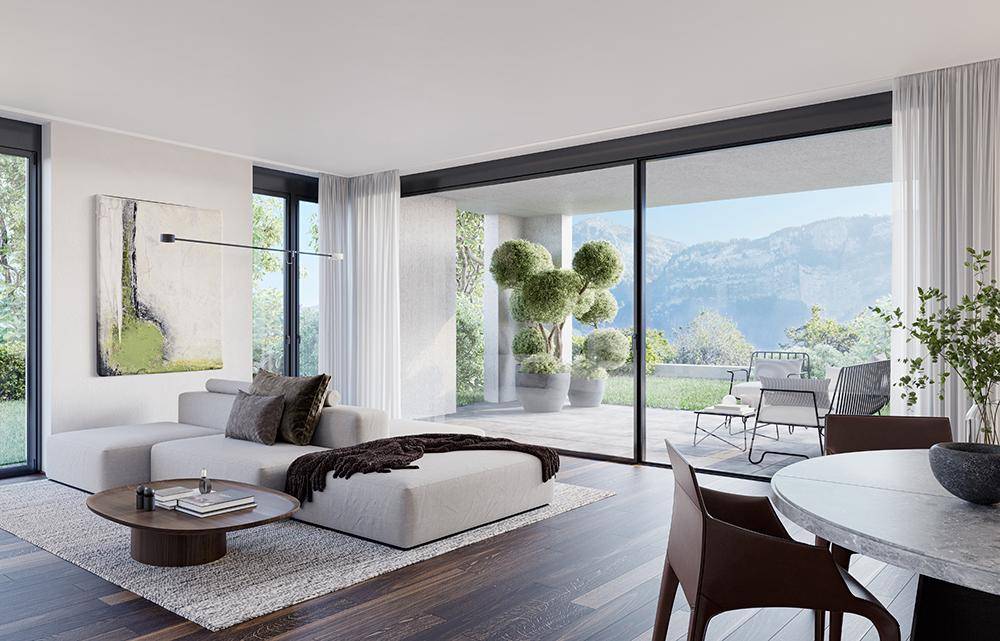 Lichtdurchfluteter Wohn-Essbereich mit großen Glasfronten und direktem Zugang zur Terrasse mit Bergblick.