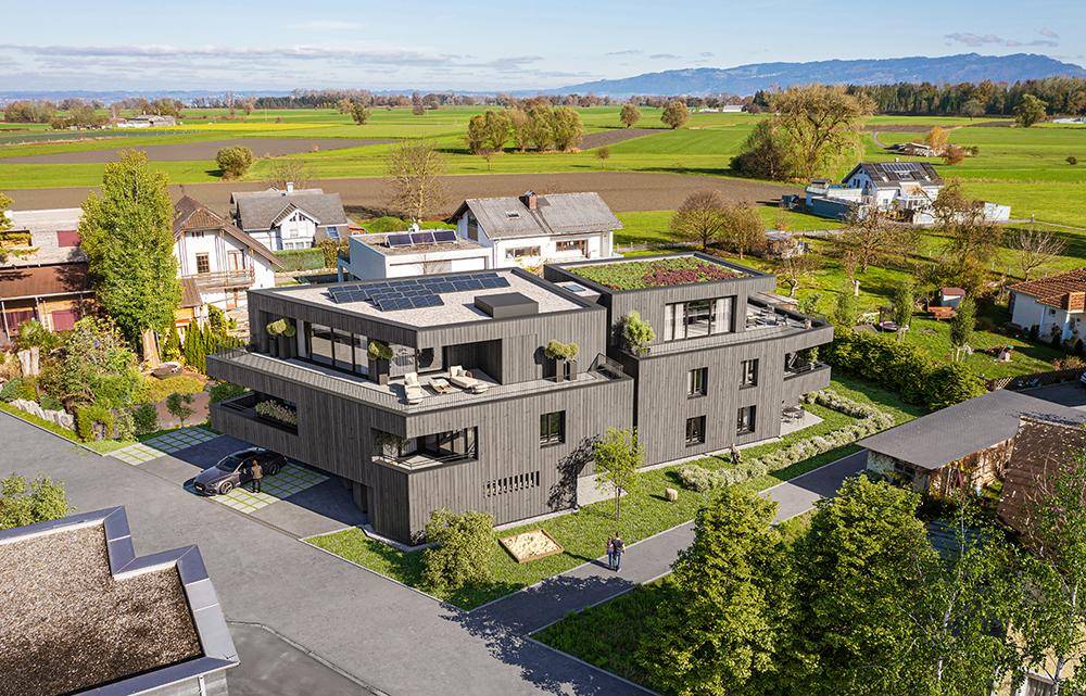Moderne Wohnanlage mit Flachdach, Gründach und Solaranlagen in ländlicher Umgebung.