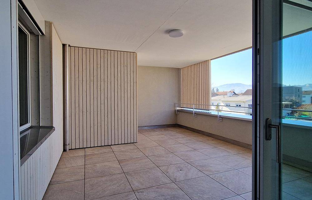Heller Balkon mit Fliesenboden und weitem Blick in die Umgebung.
