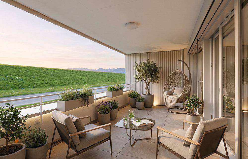 Gemütlicher Balkon mit Sitzgelegenheiten, Pflanzen und weitem Blick ins Grüne.