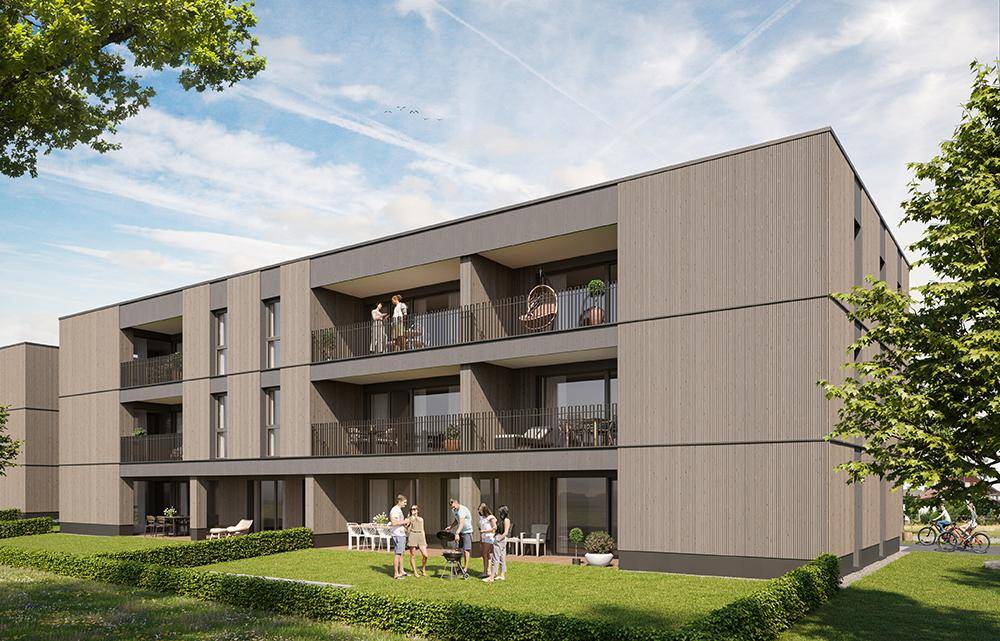 Neubau-Wohngebäude mit moderner Holzfassade, Balkonen und Terrassen, umgeben von gepflegten Grünflächen.