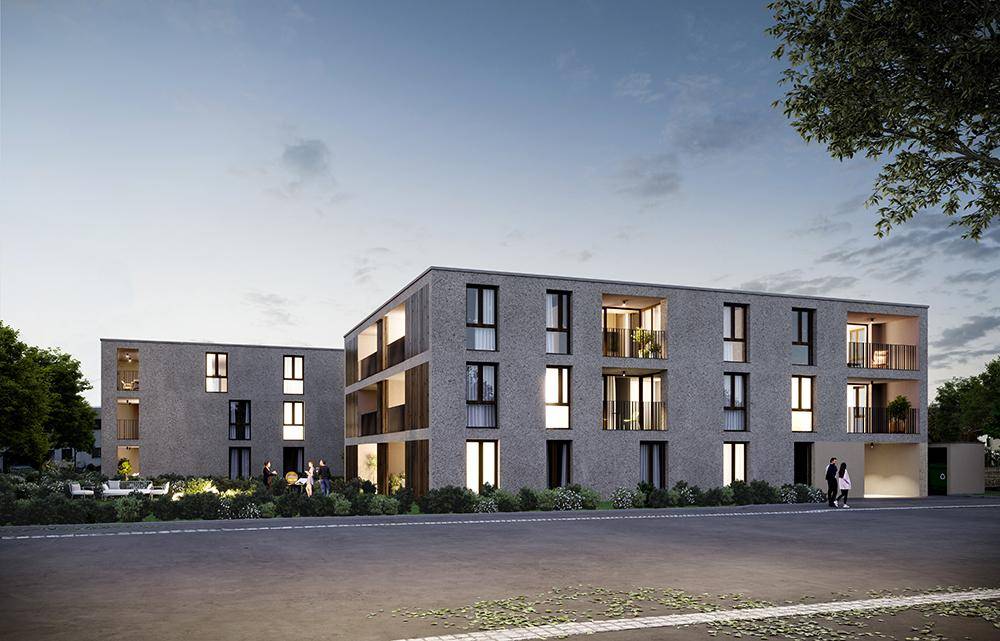 Moderne Wohngebäude mit beleuchteten Fenstern und Balkonen in der Dämmerung, umgeben von Grünflächen.
