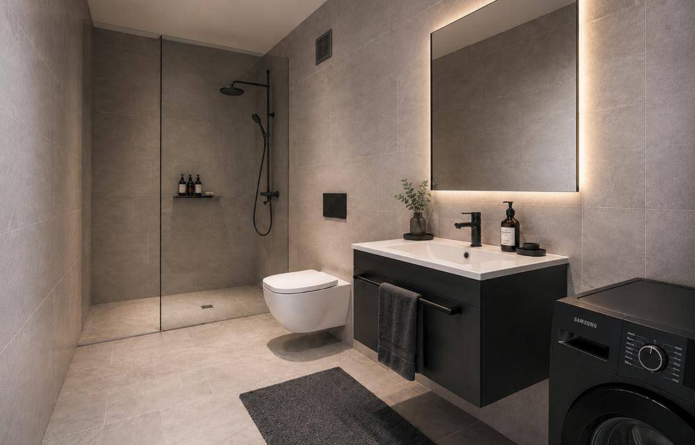 Modernes Badezimmer mit begehbarer Dusche, Wand-WC, Waschbecken und Waschmaschine.