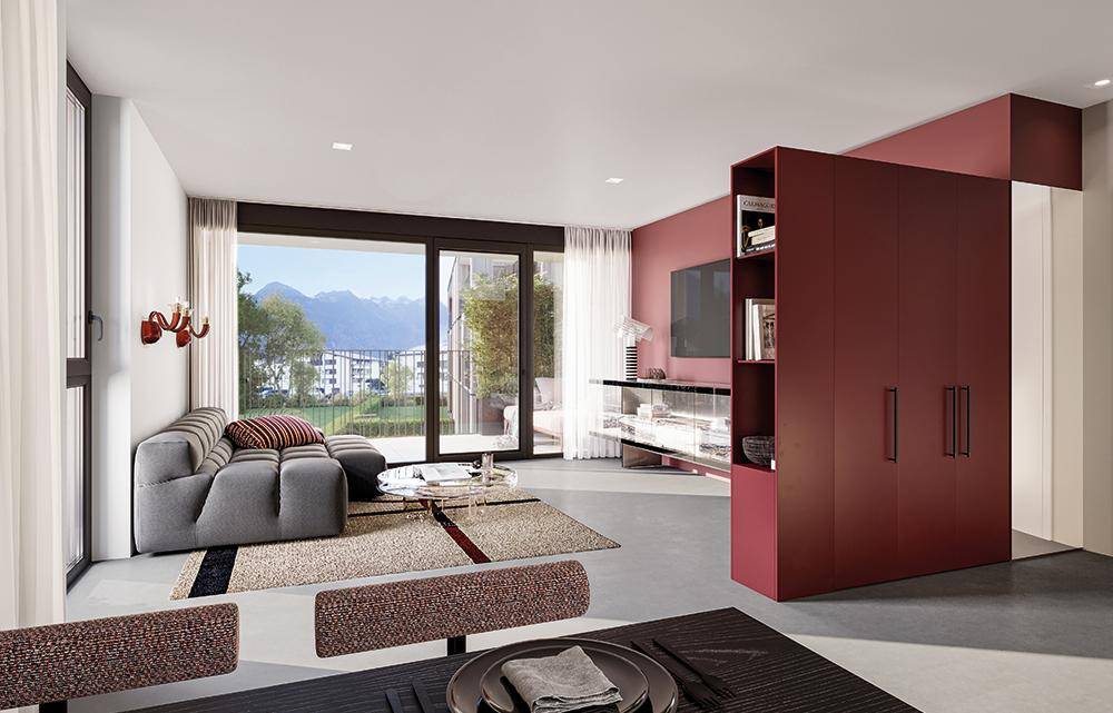 Modernes Wohnzimmer mit rotem Einbauschrank, grauem Sofa und großem Fenster mit Bergblick.