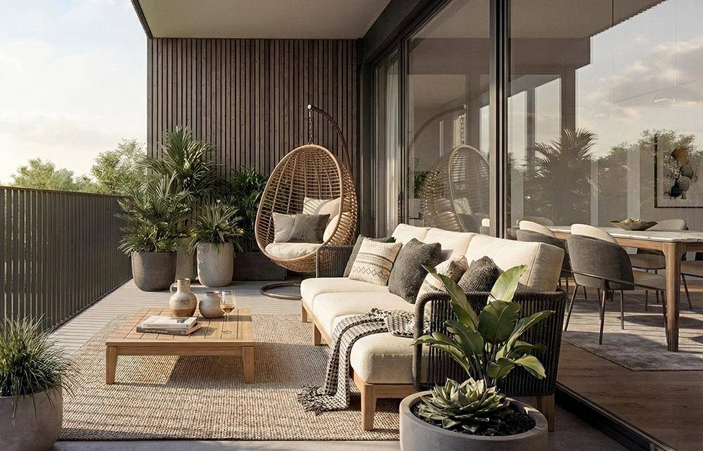 Einladender Balkon mit modernen Loungemöbeln, Pflanzen und Blick ins Grüne.