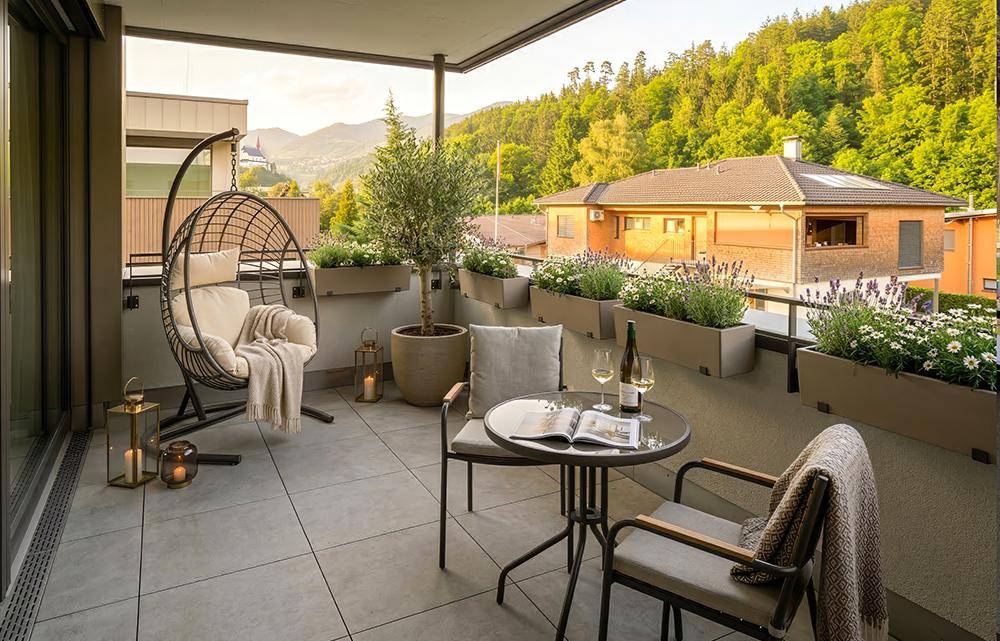 Gemütlicher Balkon mit Sitzgelegenheiten, Pflanzen und weitem Blick auf die Berge.