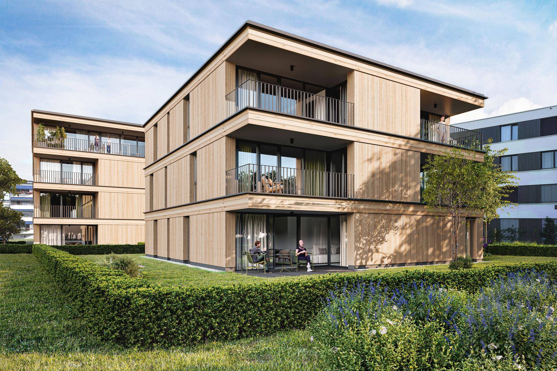 Zeitgenössisches Wohngebäude mit Holzverkleidung, Balkonen und gepflegter Gartenanlage.