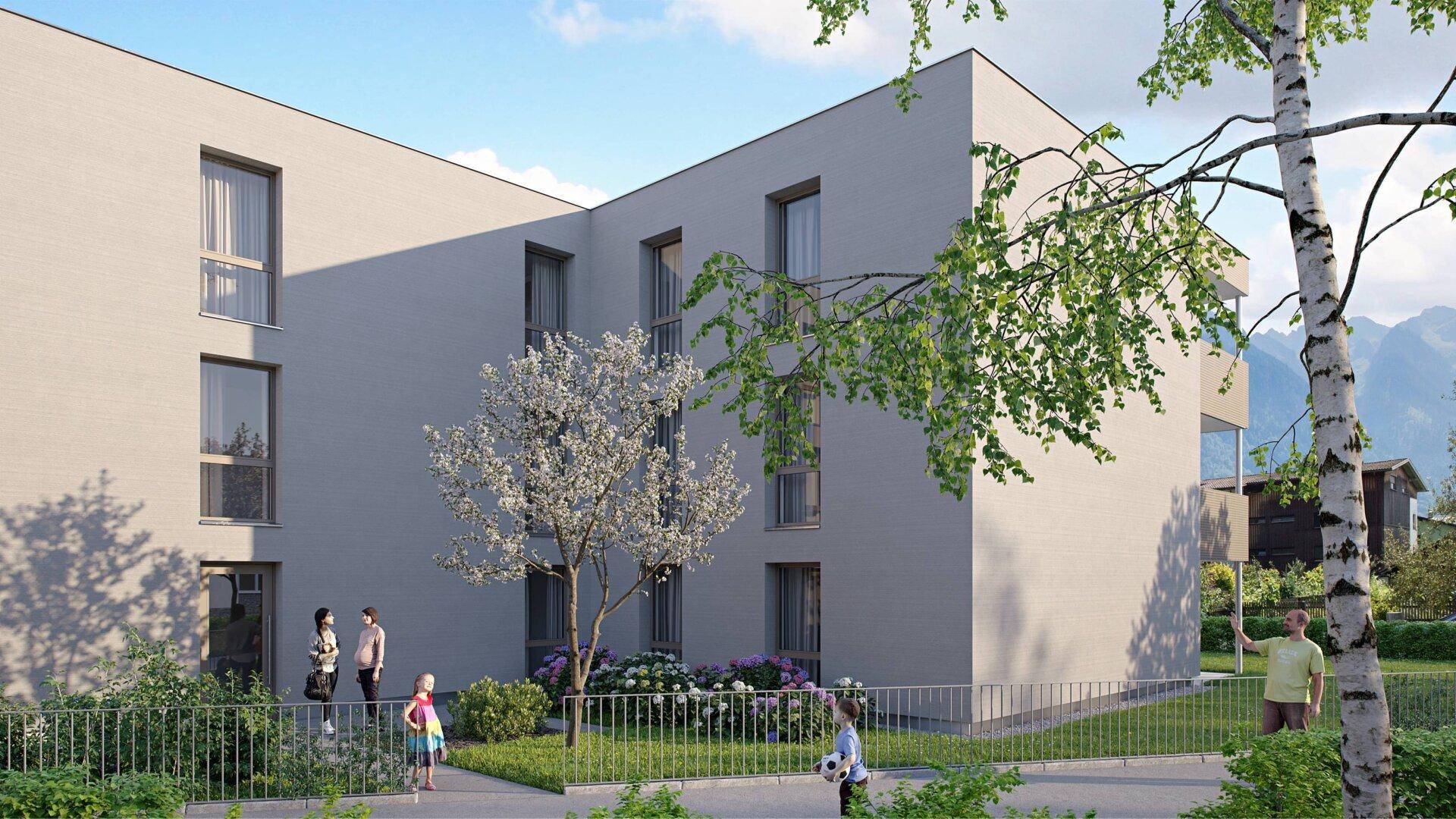 Seitenansicht eines modernen Gebäudes mit großen Fenstern und gepflegten Grünanlagen.