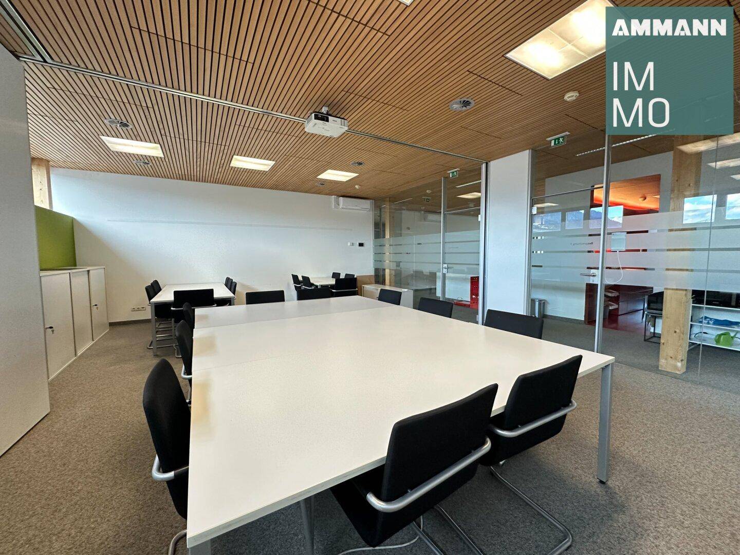 Großer Konferenzraum mit flexibler Bestuhlung, Holzdecke und Glaswänden für offene Atmosphäre.