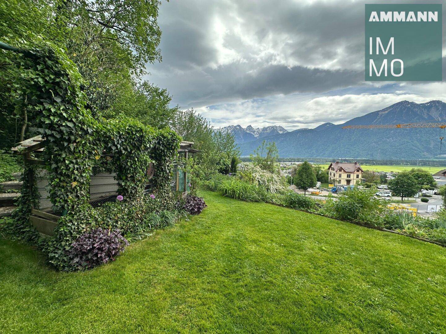 Großer Gartenbereich mit üppigem Grün und beeindruckendem Bergblick im Hintergrund.