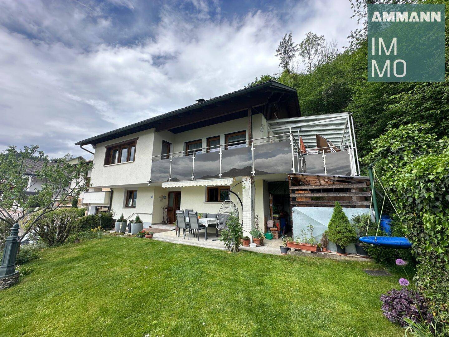 Rückseite des Hauses mit möblierter Terrasse und weitläufigem Gartenbereich.