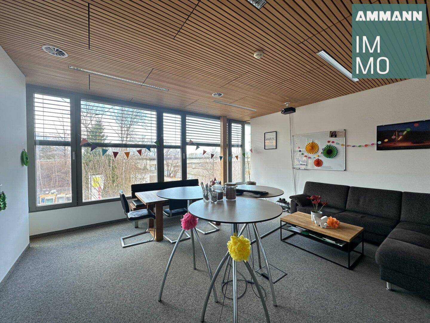 Gemütlicher Loungebereich mit Sofas, Stehtischen und Blick ins Grüne, ideal für Pausen.
