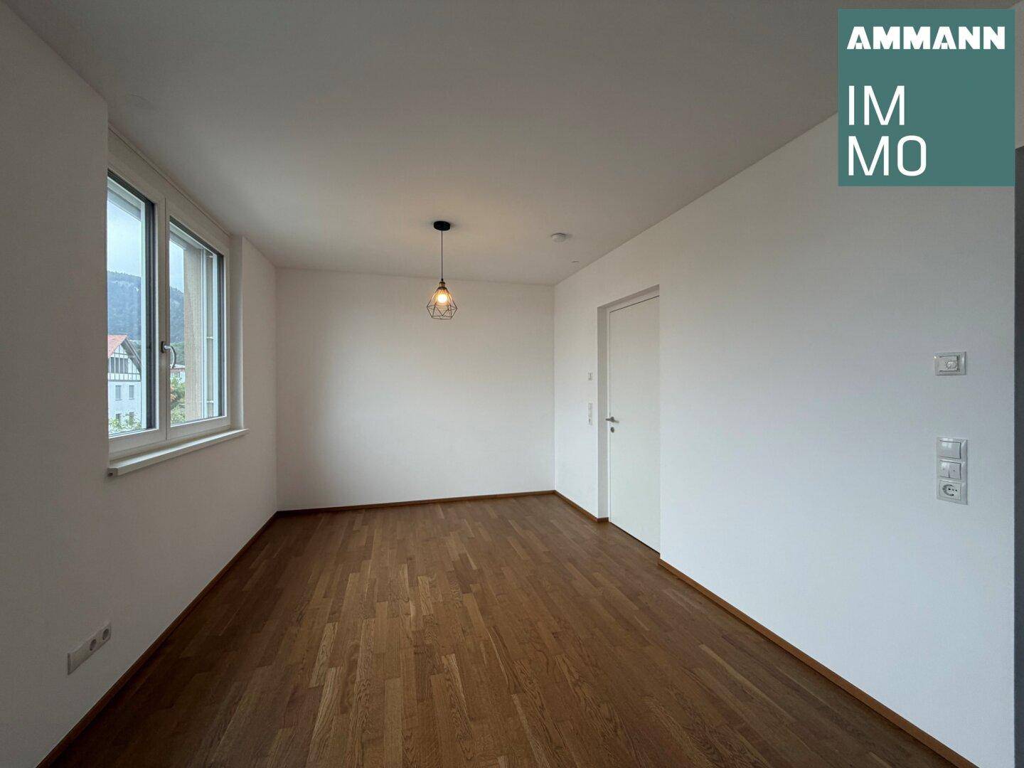 Helles Zimmer mit Holzboden, weißen Wänden und einem Fenster, bereit zur individuellen Gestaltung.