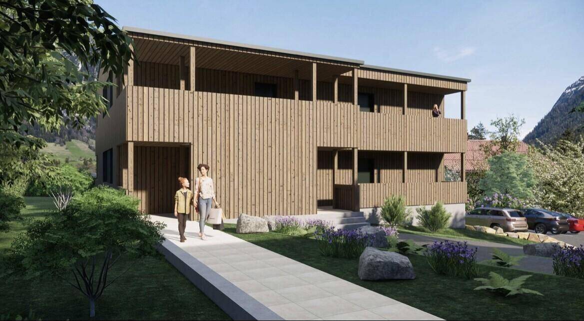Attraktives Mehrfamilienhaus mit Holzfassade, überdachten Balkonen und gepflegter Außenanlage.