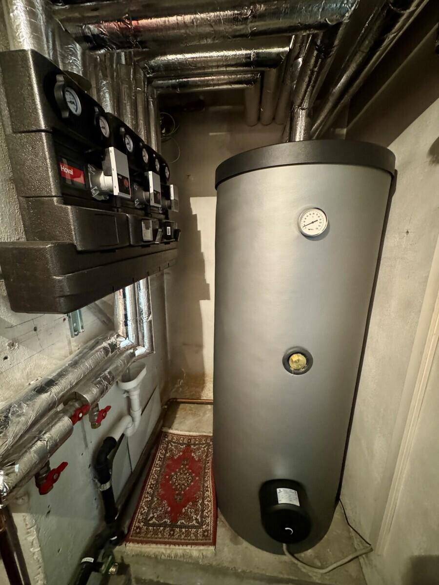 Heizungsraum mit Warmwasserspeicher, Rohrleitungen und Steuerungselementen für die Haustechnik.