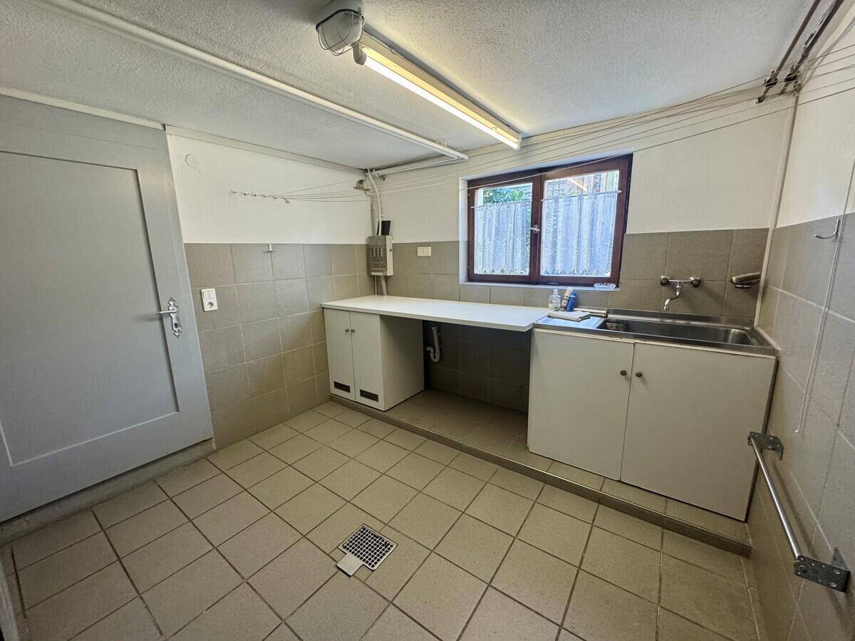 Hauswirtschaftsraum mit Waschbecken, Arbeitsfläche und Fenster, praktisch und funktional.