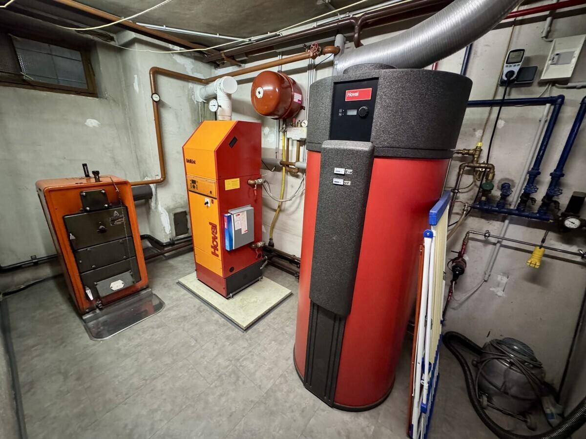 Heizungsraum im Keller mit zwei modernen Heizkesseln und technischen Installationen.