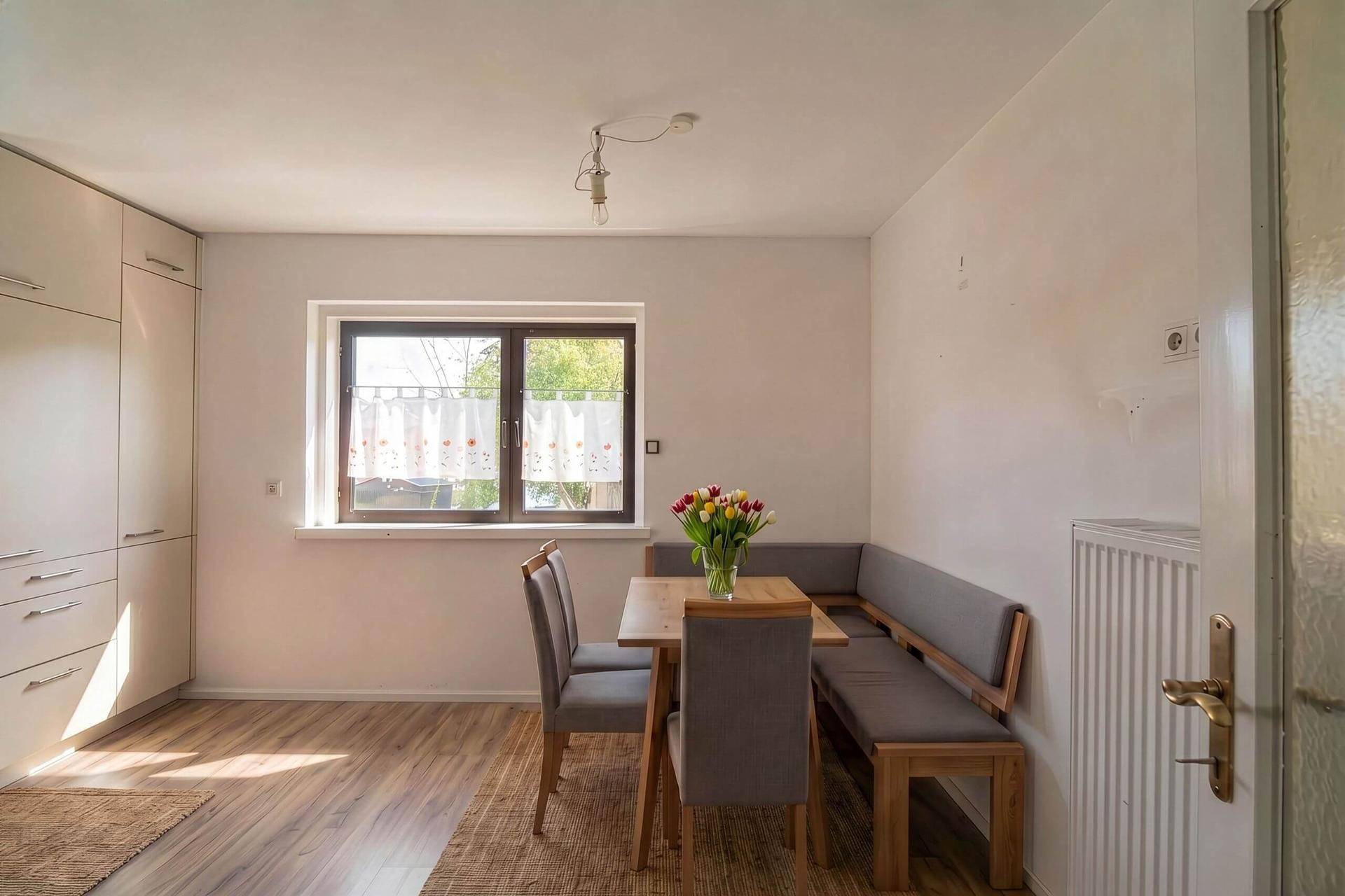 Gemütlicher Essbereich mit Holztisch, Sitzbank und Fenster, perfekt für gemeinsame Mahlzeiten.