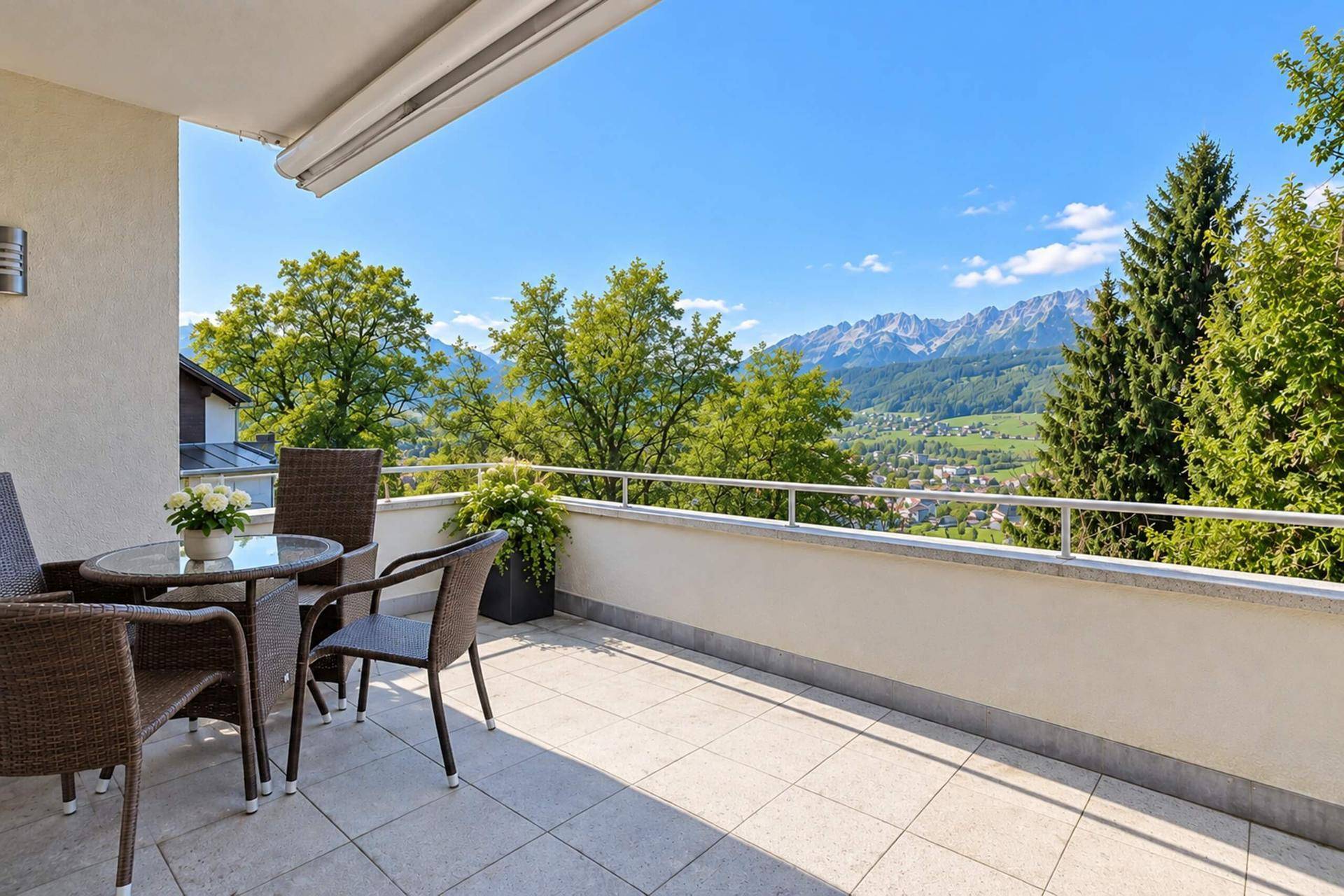 Sonniger Balkon mit Sitzgelegenheiten und einem atemberaubenden Panoramablick auf die Berge.