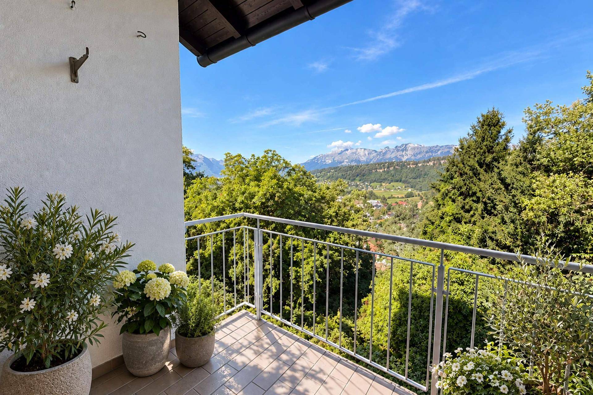 Kleiner Balkon mit Pflanzen und weitem Blick auf die Berge und die umliegende Landschaft.