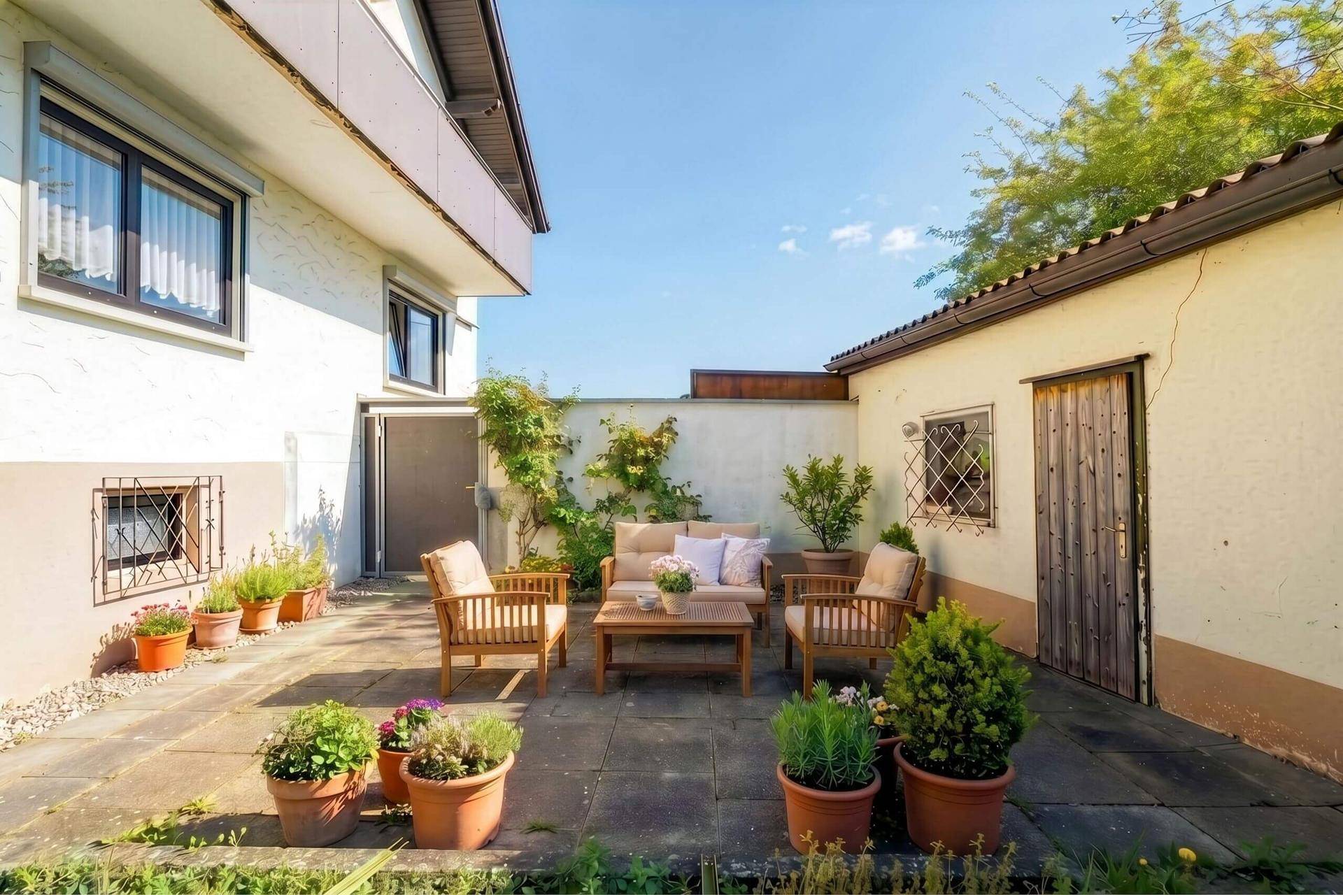 Gemütliche Terrasse mit Sitzmöbeln und Topfpflanzen im Freien, ideal zum Entspannen.