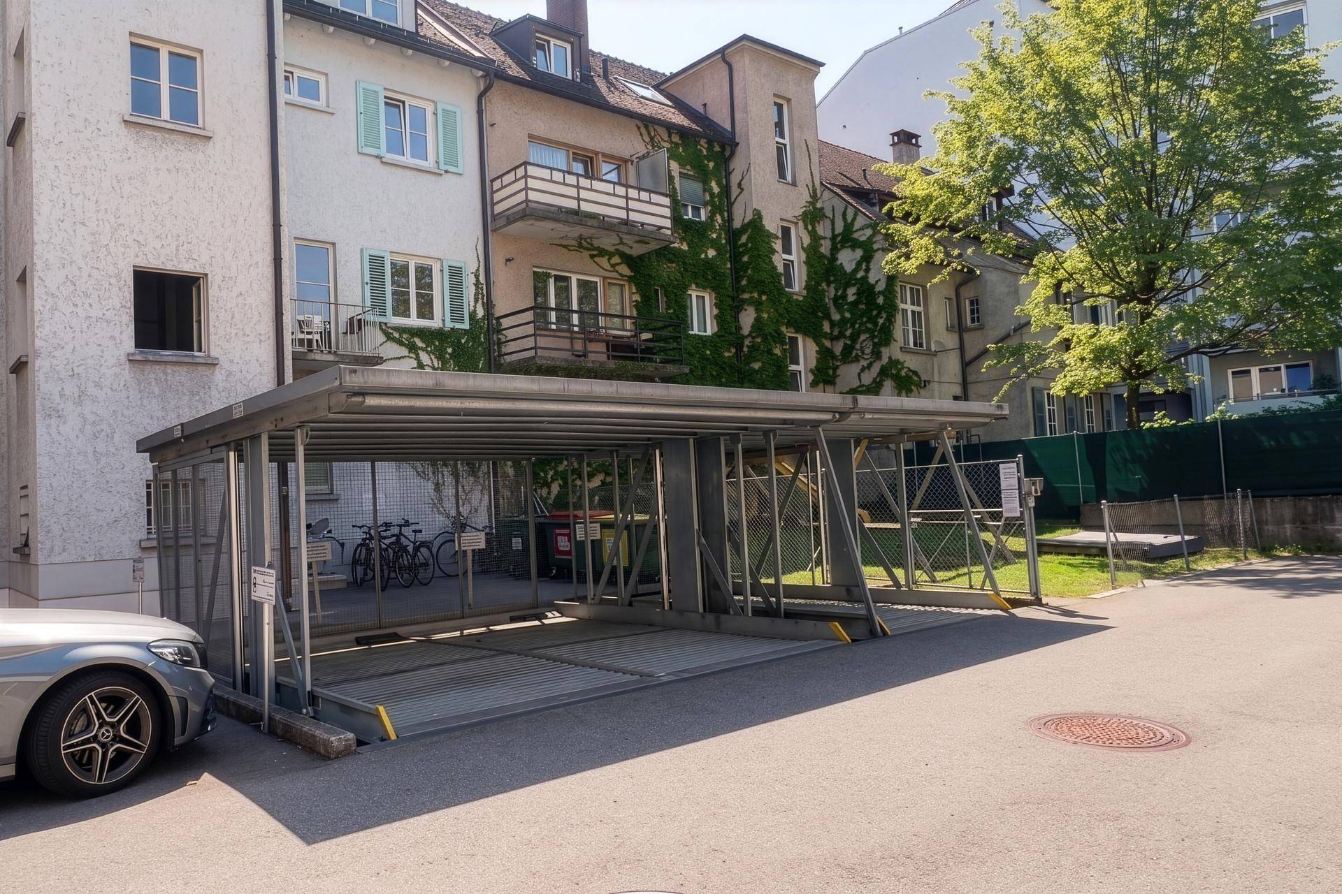 Außenansicht eines Gebäudes mit integriertem Parksystem und begrünten Fassadenbereichen.