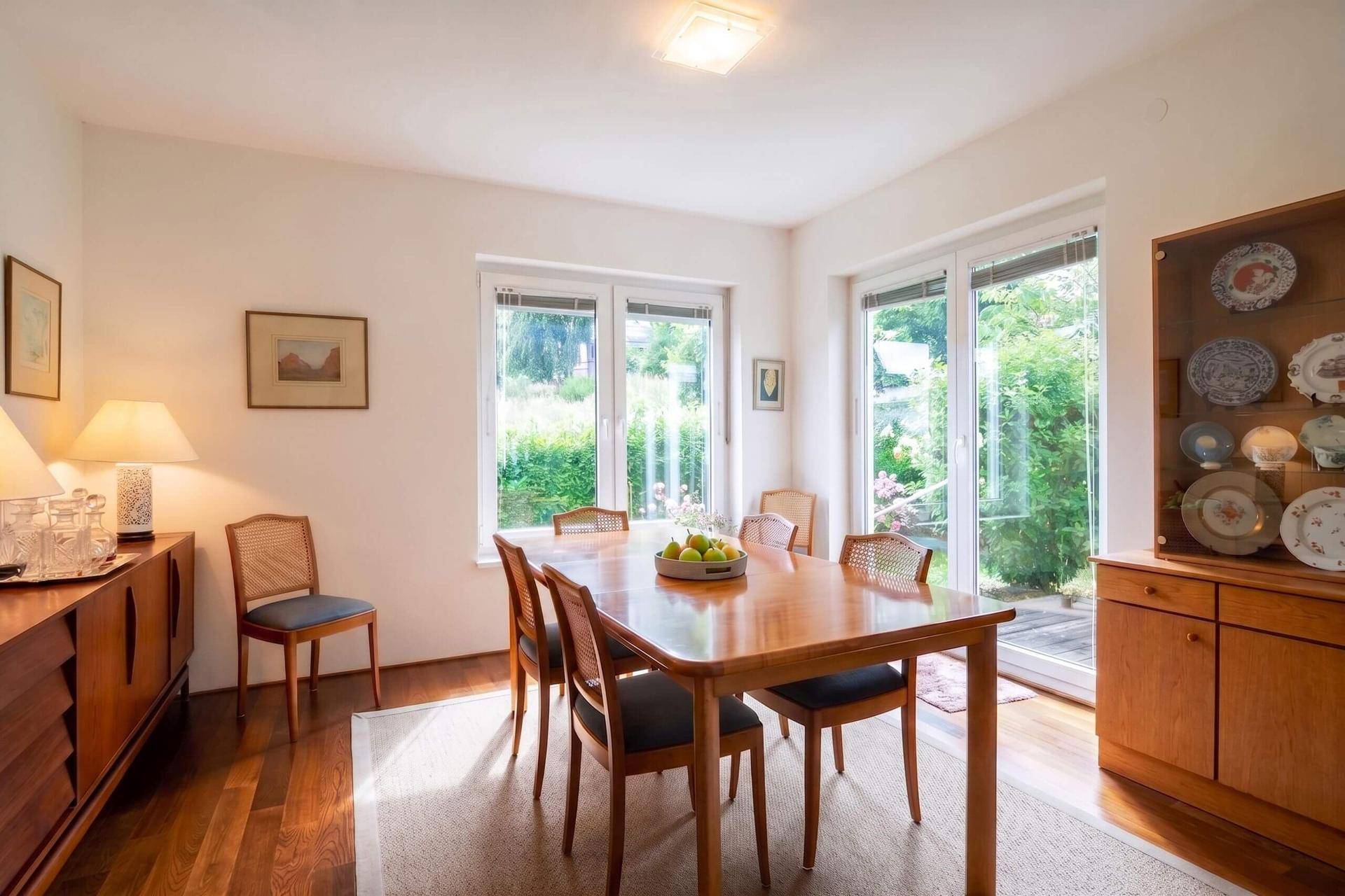 Heller Essbereich mit Holztisch, Parkettboden und Zugang zum Garten.