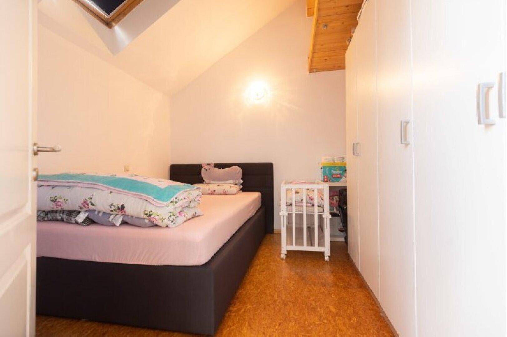 Gemütliches Schlafzimmer im Dachgeschoss mit Dachfenster und Einbauschränken, bietet viel Stauraum.