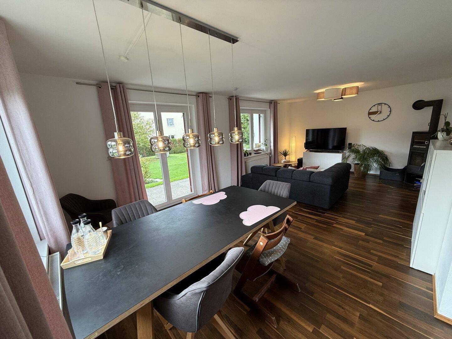 Offener Wohn-Essbereich mit Holzboden, Esstisch und Blick in den Garten.