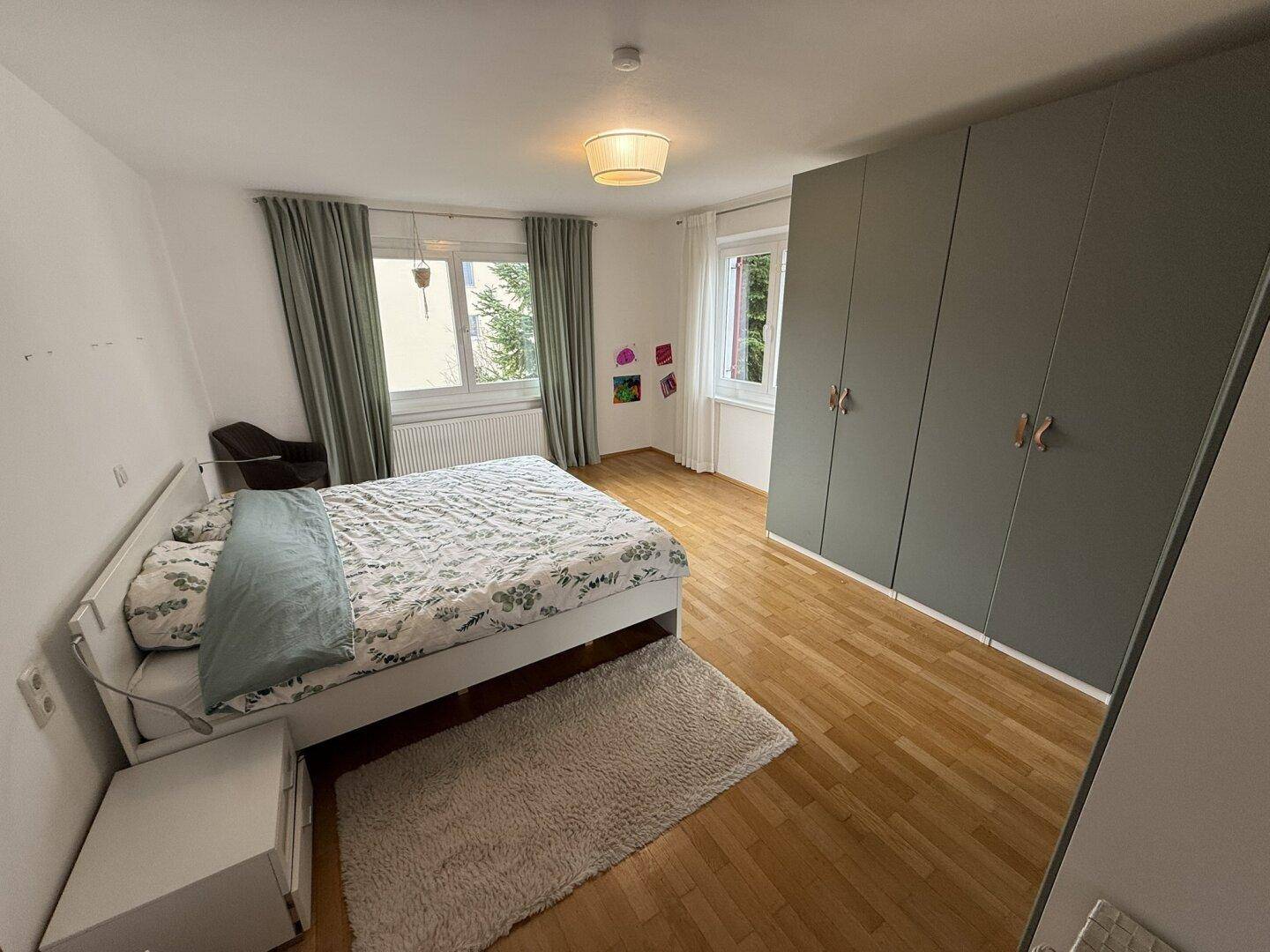 Geräumiges Schlafzimmer mit Holzboden, großem Bett und Einbauschränken.