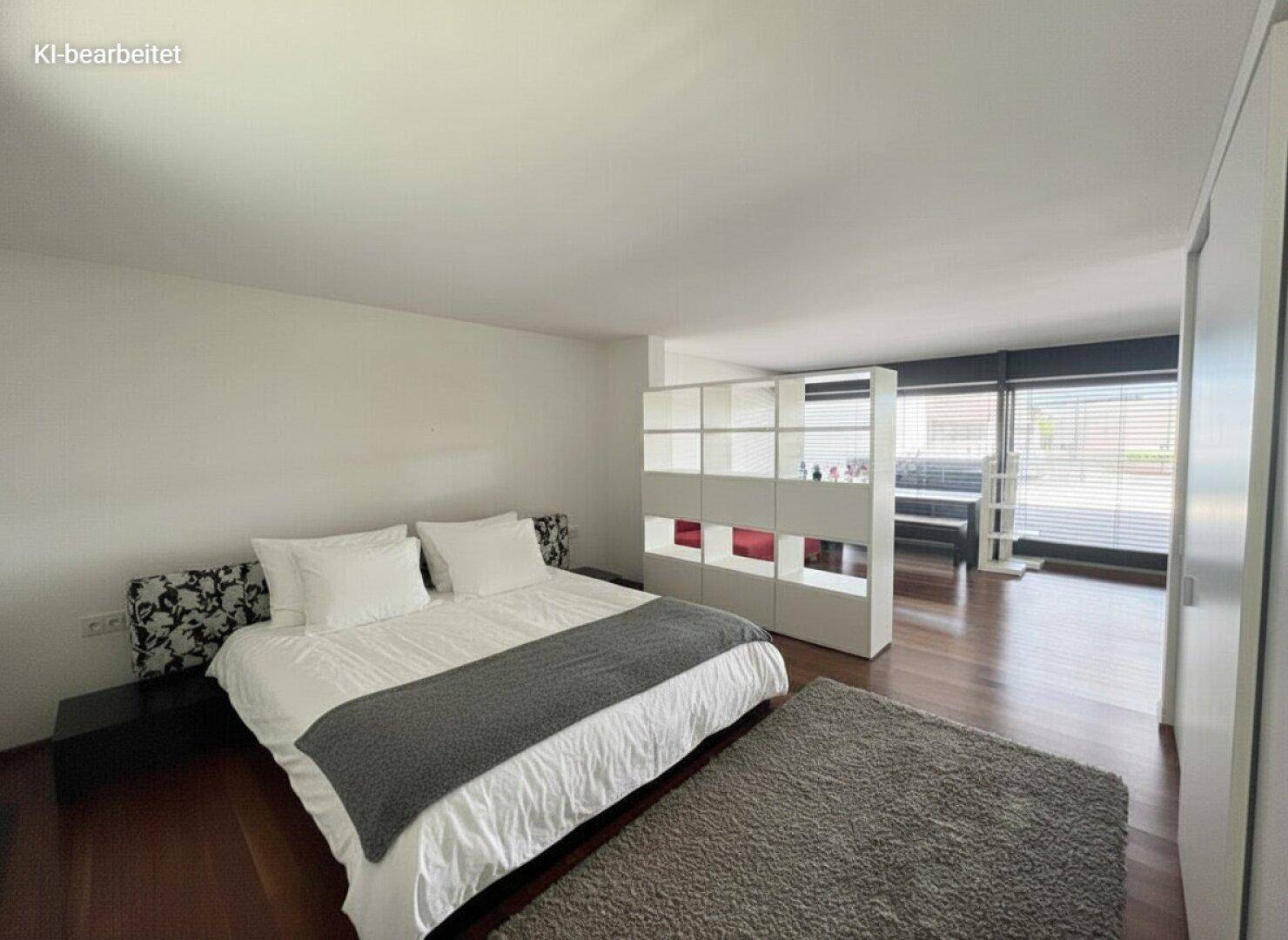 Geräumiges Schlafzimmer mit großem Bett, dunklem Holzboden und weißer Einrichtung, die eine ruhige Atmosphäre schafft.