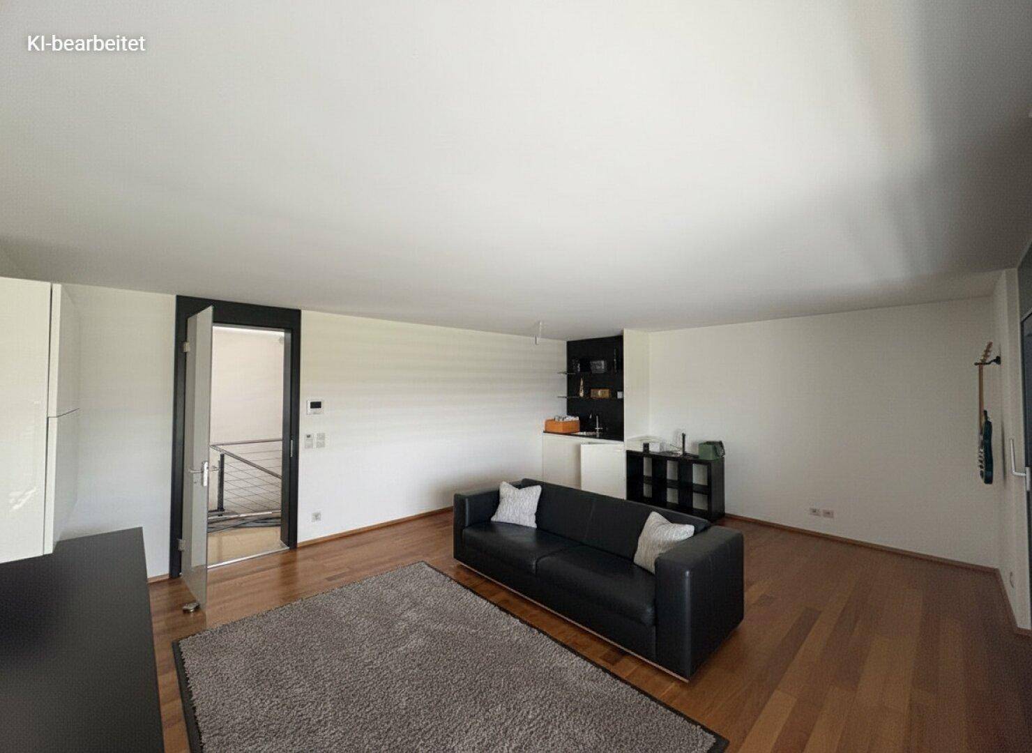 Helles Wohnzimmer mit dunklem Sofa, Holzboden und einer kleinen Bar, ideal für entspannte Abende.