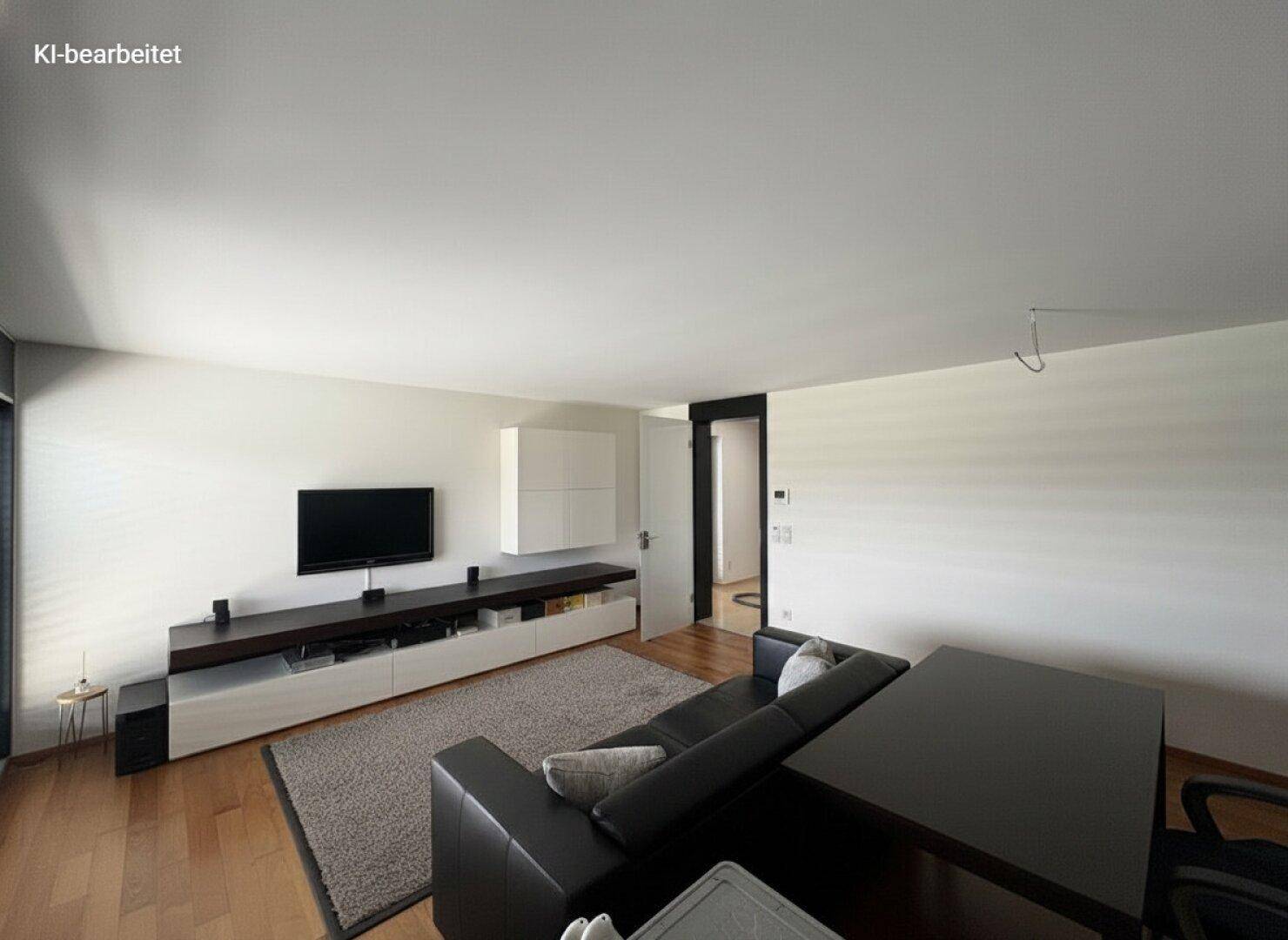 Wohnzimmer mit TV-Möbeln, dunklem Sofa und Holzboden, ergänzt durch einen großen Teppich.