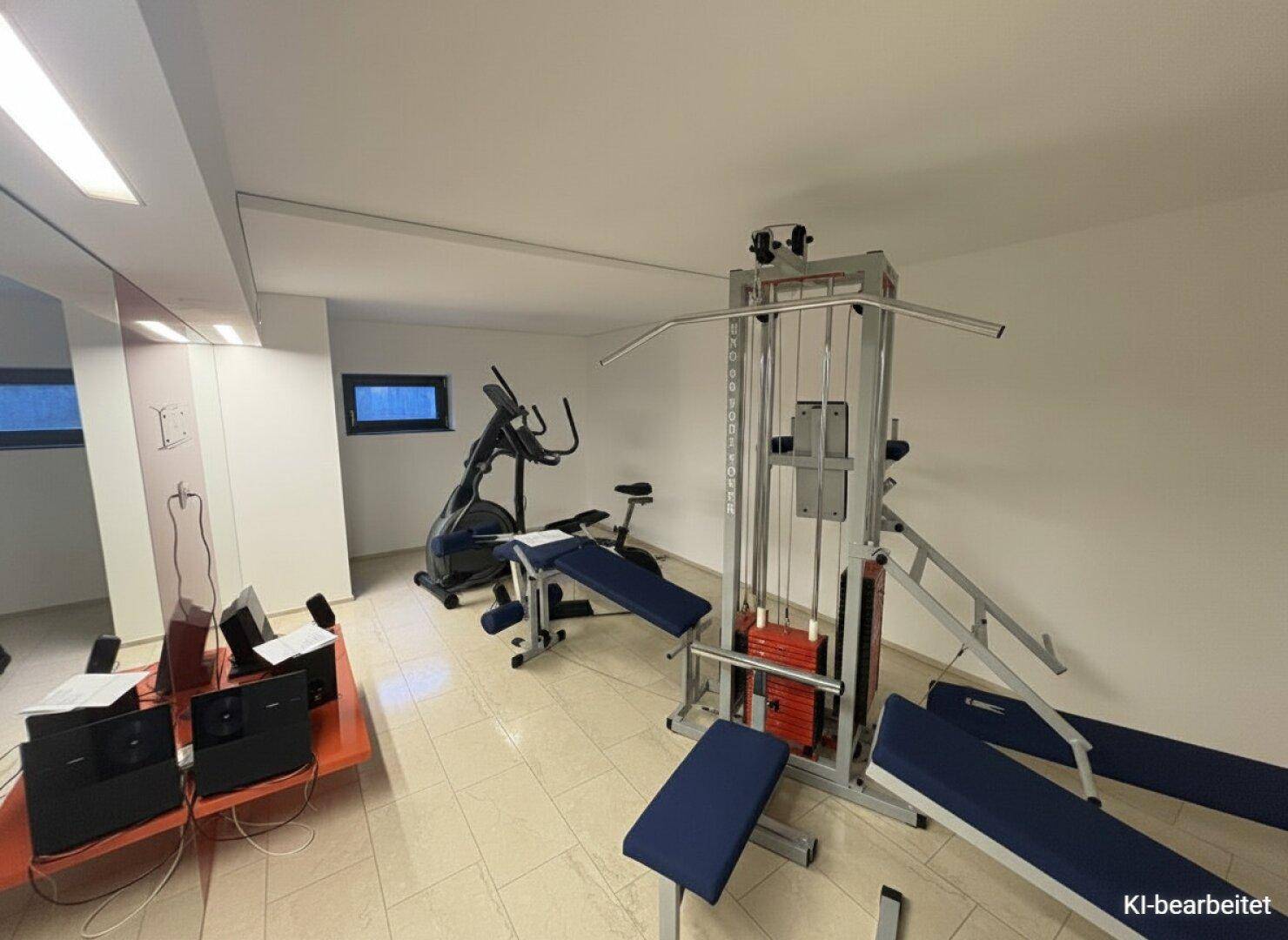 Gut ausgestatteter Fitnessraum mit verschiedenen Trainingsgeräten für das tägliche Workout.
