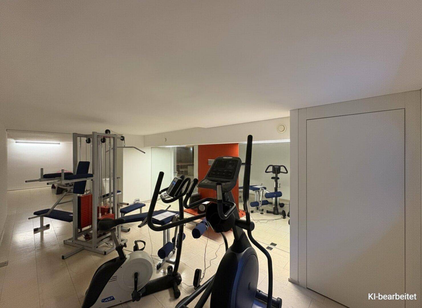 Weiterer Blick in den Fitnessraum mit Crosstrainer, Hantelbank und weiteren Sportgeräten.