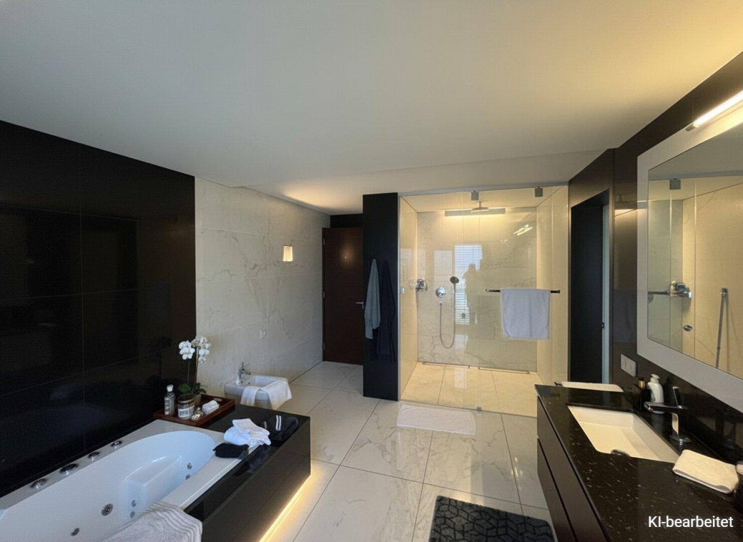 Luxuriöses Badezimmer mit Whirlpool, begehbarer Dusche, Bidet und hellen Marmorfliesen.