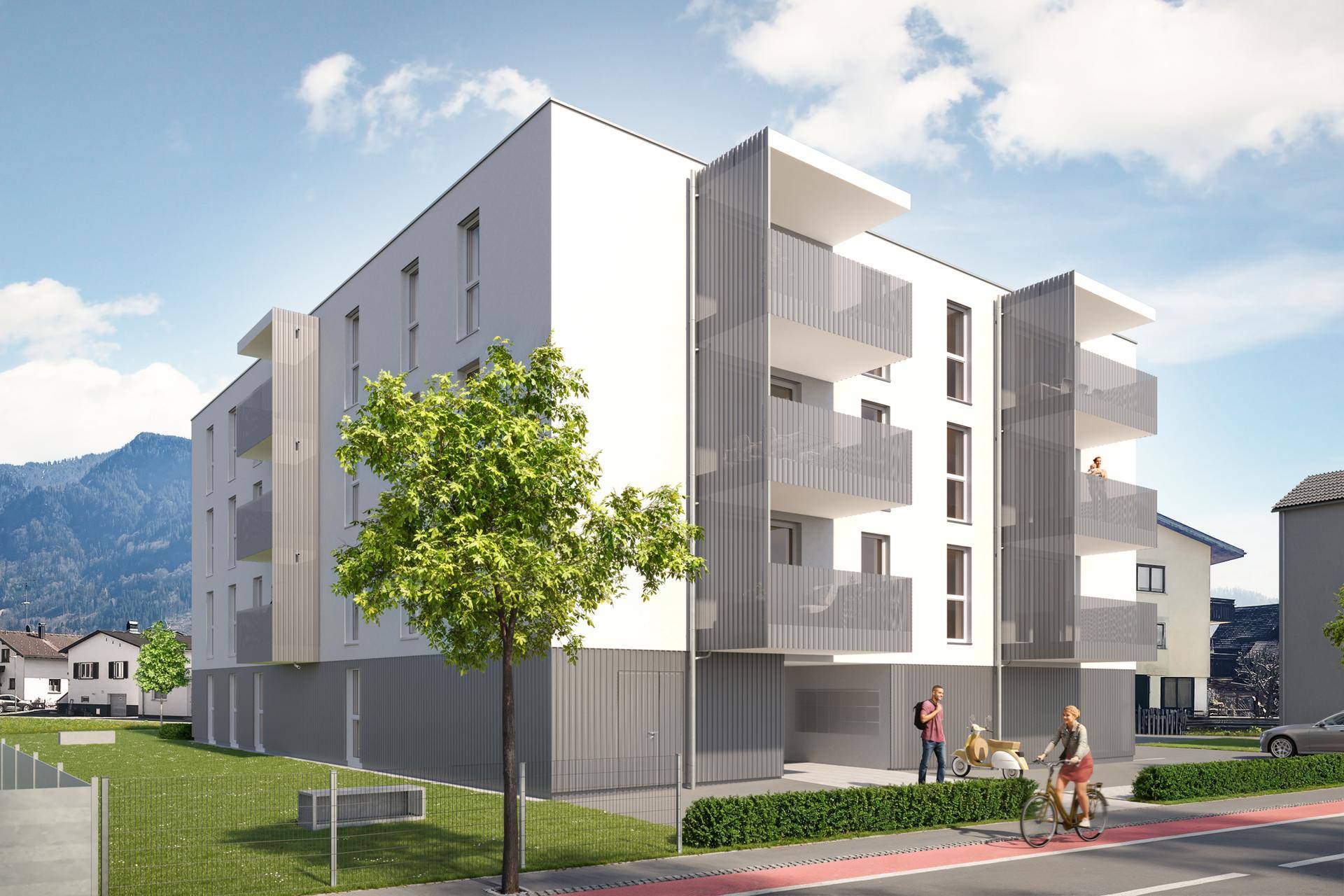 Moderne Wohnanlage mit Balkonen und einer ansprechenden Fassade vor bergiger Kulisse.
