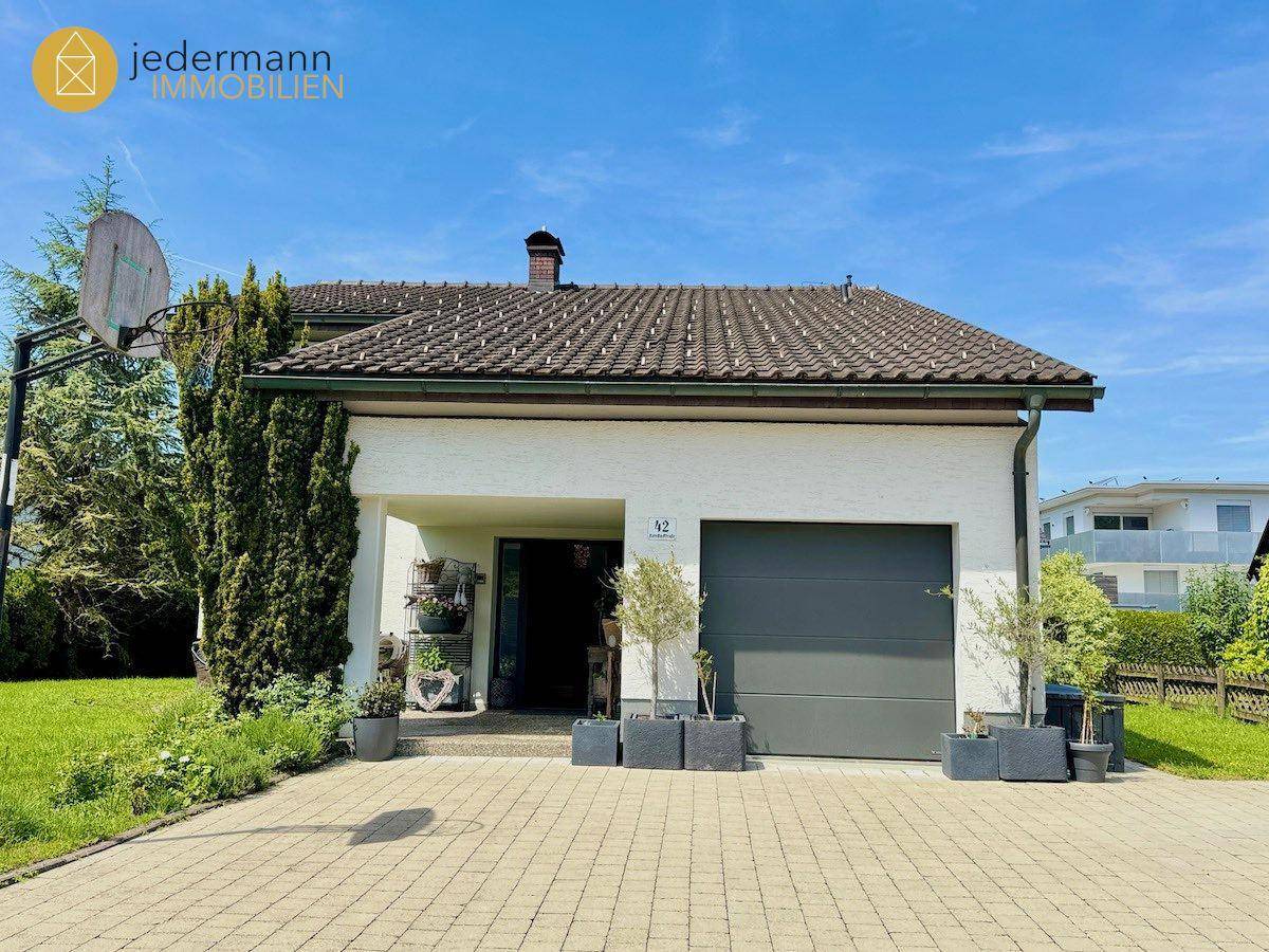 Einfamilienhaus mit Garage, gepflasterter Auffahrt und gepflegtem Vorgarten.